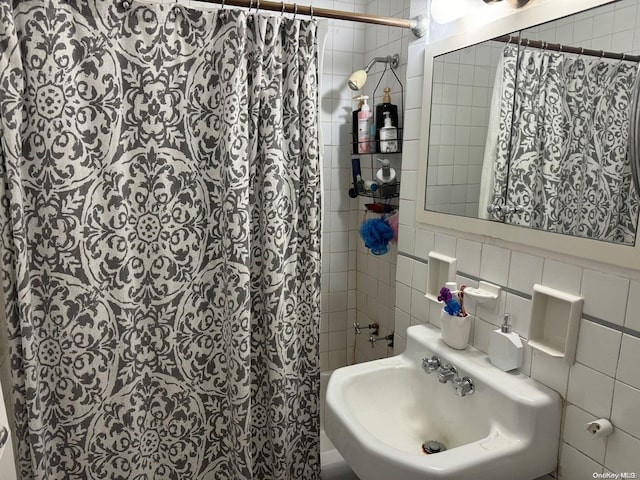 bathroom featuring decorative backsplash, tile walls, and sink