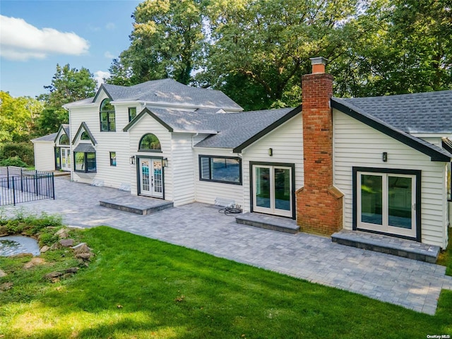 rear view of house with a yard, a patio, and french doors