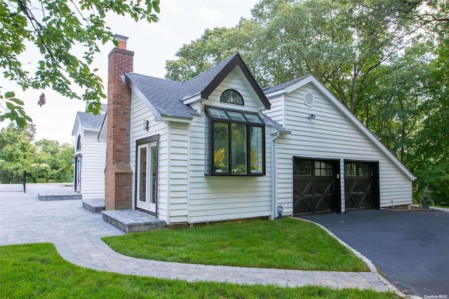 view of side of property with a garage and a yard