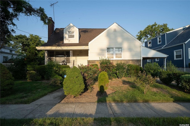 cape cod home with a front lawn and covered porch