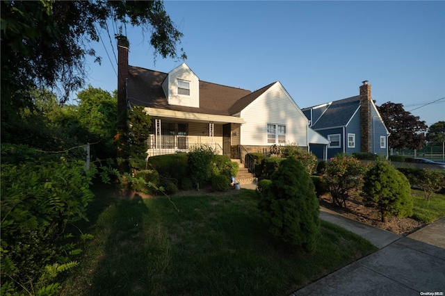 cape cod house with a front lawn and a porch