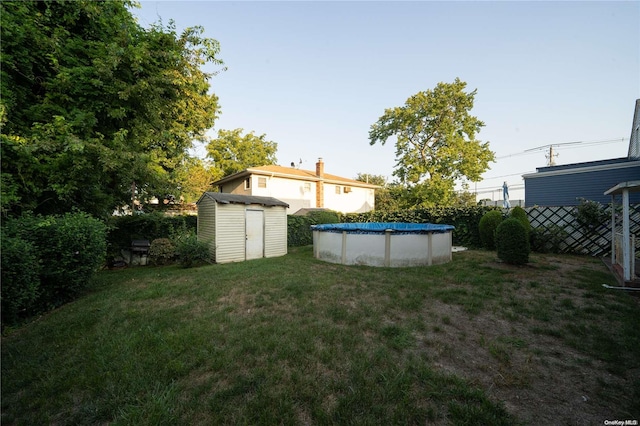 view of yard featuring a storage unit and a covered pool