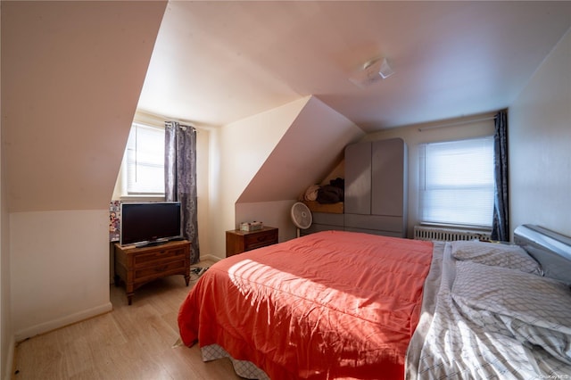 bedroom featuring lofted ceiling and light hardwood / wood-style flooring