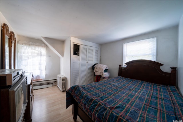 bedroom featuring radiator, a closet, light hardwood / wood-style flooring, and a baseboard radiator