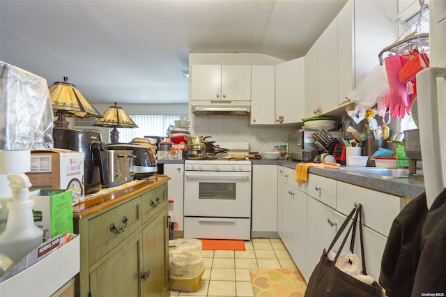 kitchen featuring light tile patterned flooring, white cabinetry, white gas range oven, and tasteful backsplash