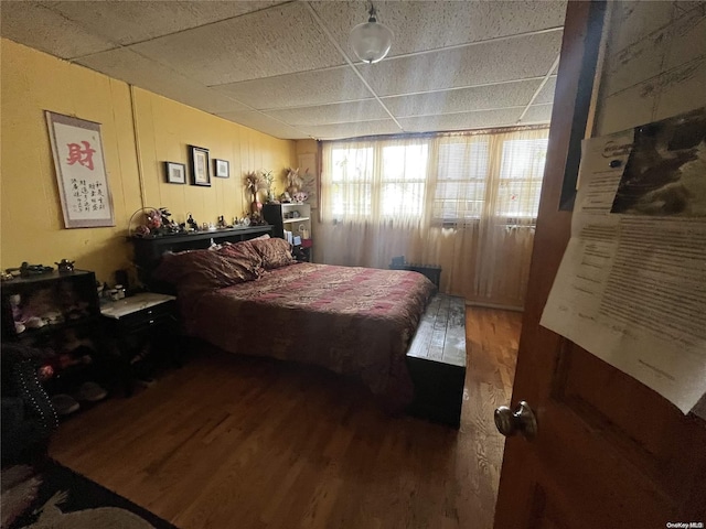 bedroom with wood-type flooring and a paneled ceiling