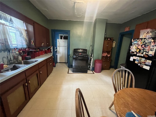 kitchen featuring stainless steel fridge, black fridge, and sink