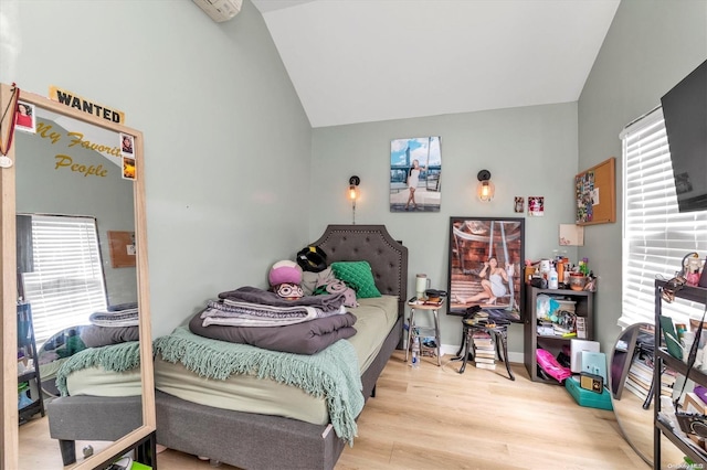 bedroom featuring light hardwood / wood-style floors and vaulted ceiling