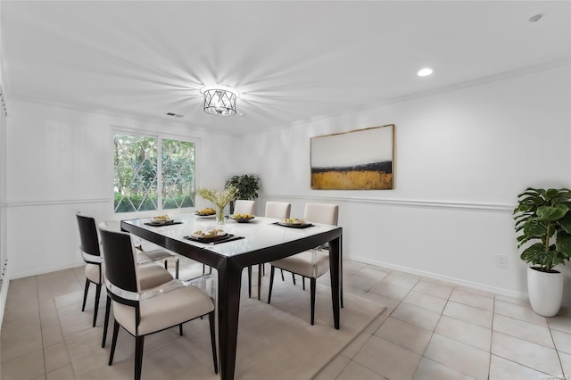 dining room featuring ornamental molding and light tile patterned flooring