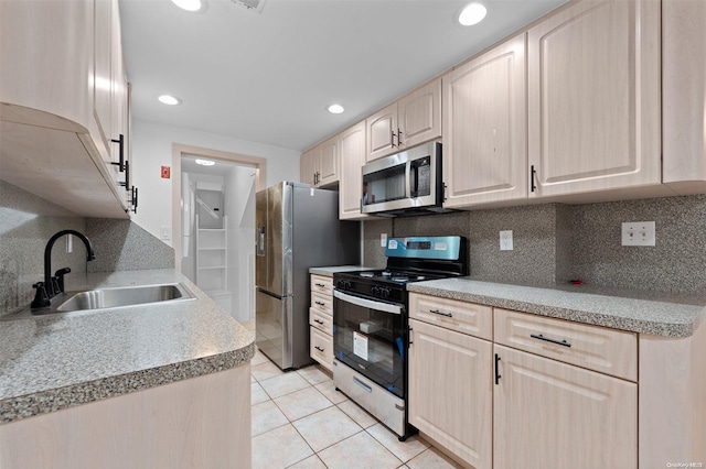 kitchen featuring light brown cabinets, backsplash, sink, light tile patterned floors, and stainless steel appliances