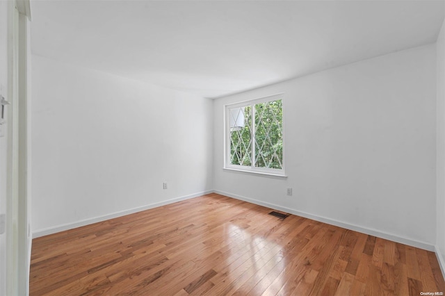 unfurnished room with wood-type flooring