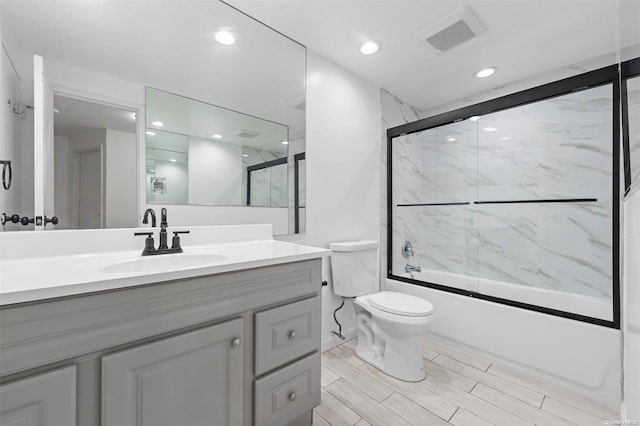 full bathroom with vanity, toilet, and bath / shower combo with glass door