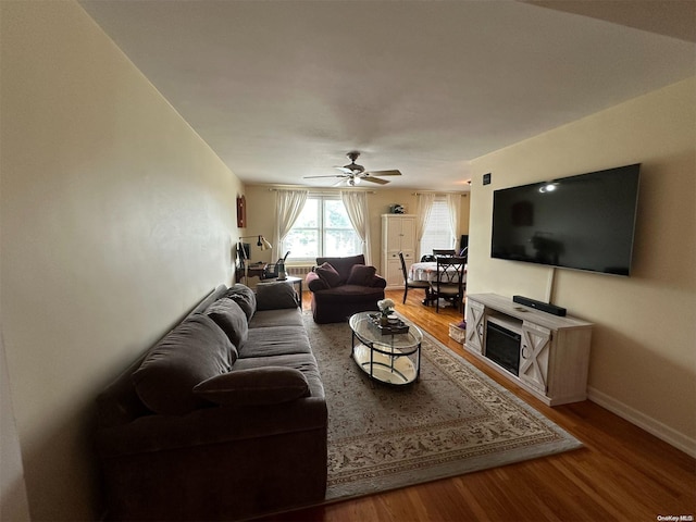 living room featuring hardwood / wood-style floors and ceiling fan