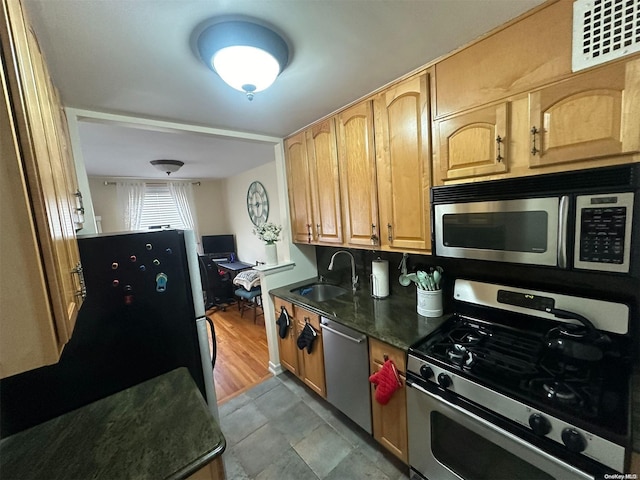 kitchen featuring sink, light tile patterned floors, and stainless steel appliances