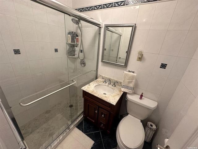 bathroom featuring toilet, vanity, tile walls, and walk in shower