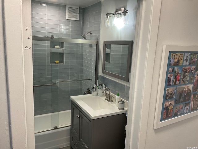 bathroom with vanity and combined bath / shower with glass door