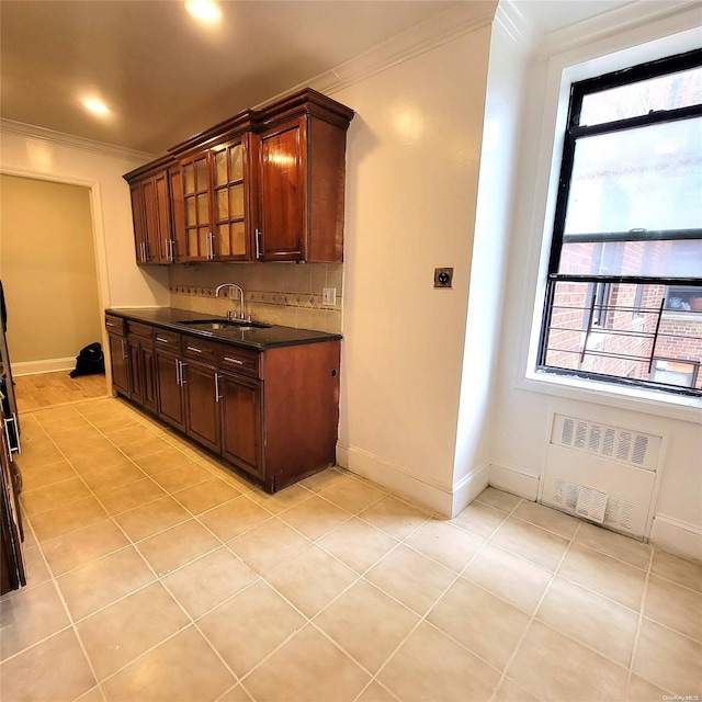 kitchen with radiator heating unit, sink, light tile patterned floors, and ornamental molding