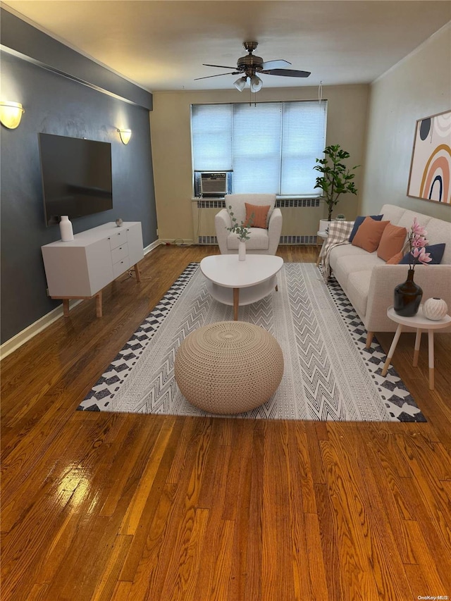 living room with hardwood / wood-style floors, ceiling fan, cooling unit, and radiator heating unit