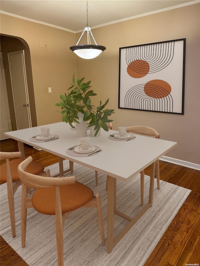 dining room with hardwood / wood-style floors and ornamental molding