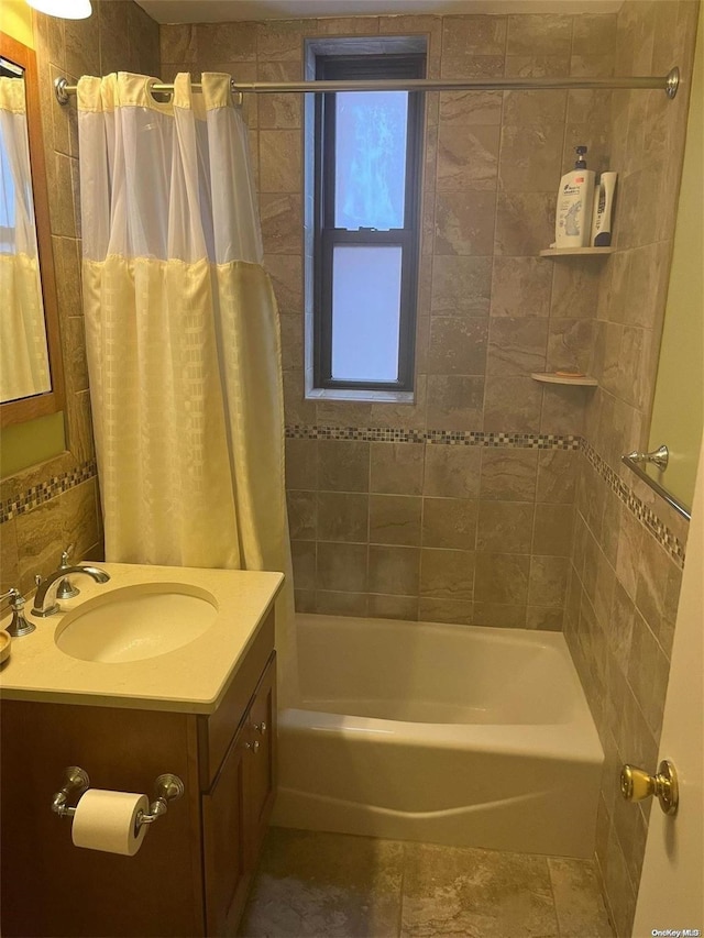 bathroom with vanity, shower / bath combo, and tile walls