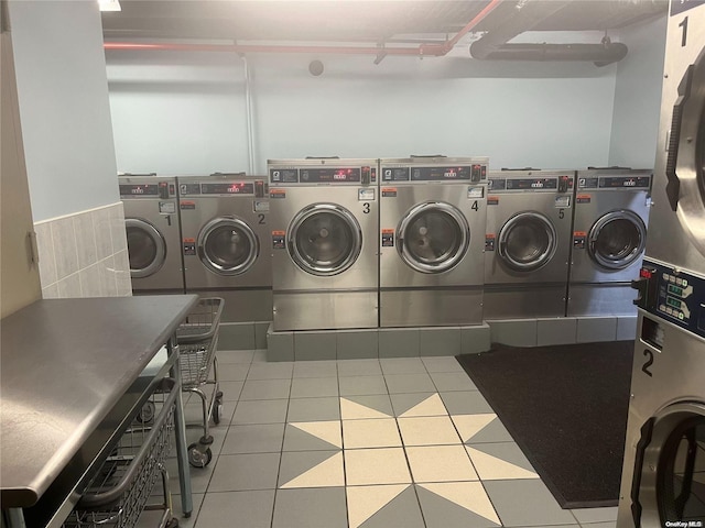 washroom with light tile patterned floors and washer and dryer