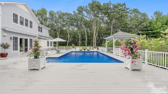 view of swimming pool featuring a gazebo, a wooden deck, and an outdoor living space