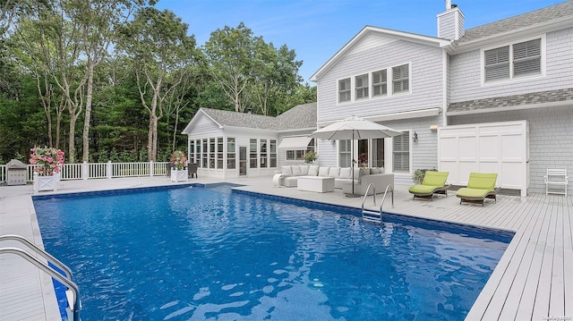 view of pool with an outdoor living space and a wooden deck