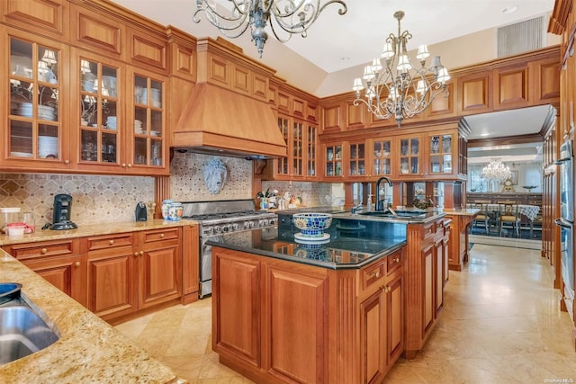 kitchen with a center island, a notable chandelier, dark stone countertops, stainless steel stove, and custom exhaust hood