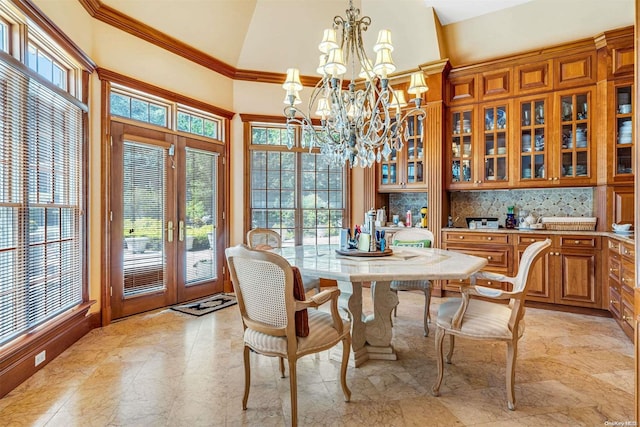 dining space with crown molding, french doors, high vaulted ceiling, and an inviting chandelier