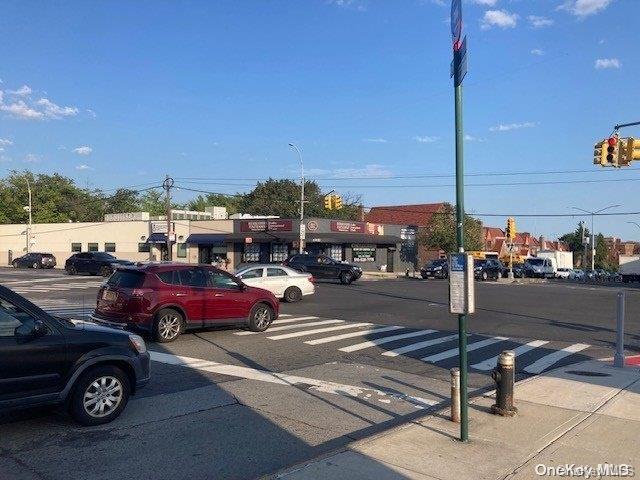 view of asphalt street with traffic lights, sidewalks, and traffic signs