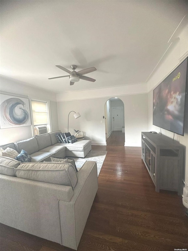 living room with dark hardwood / wood-style flooring, ceiling fan, and ornamental molding