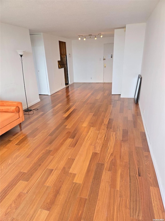 empty room with wood-type flooring and a textured ceiling