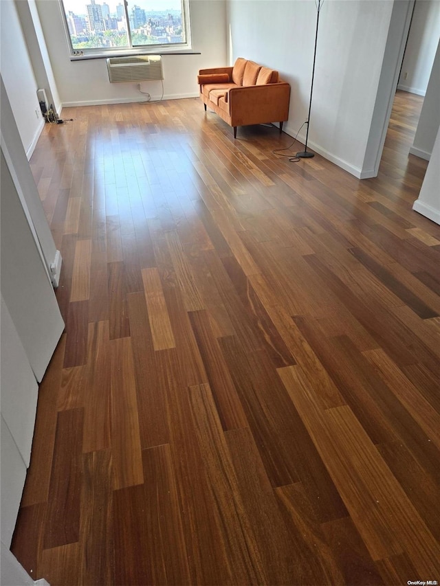 interior space with hardwood / wood-style flooring and a wall unit AC