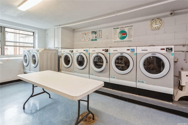 clothes washing area featuring washer and dryer and a textured ceiling