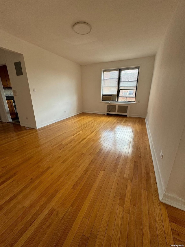 empty room with light hardwood / wood-style floors and radiator