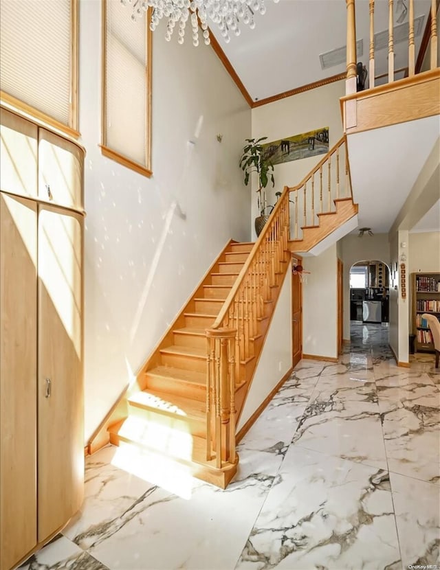 stairs featuring high vaulted ceiling, crown molding, and a healthy amount of sunlight