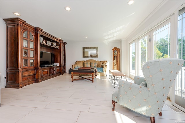 sitting room featuring light tile patterned floors, a wealth of natural light, and ornamental molding