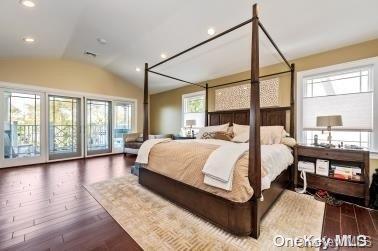 bedroom featuring access to exterior, lofted ceiling, and dark wood-type flooring