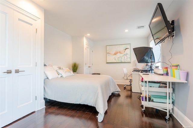 bedroom with dark wood-type flooring and a closet