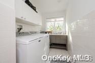 laundry room featuring washing machine and dryer and cabinets