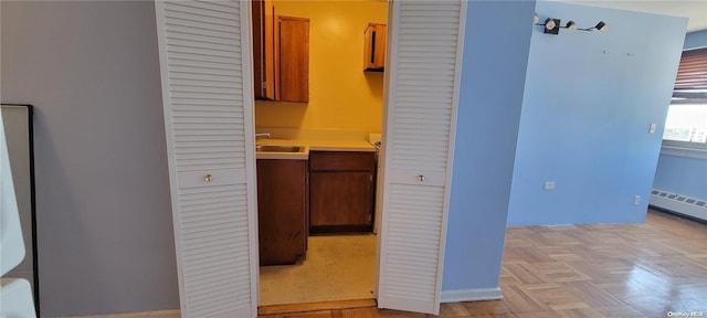 interior space featuring baseboard heating, sink, and light parquet floors