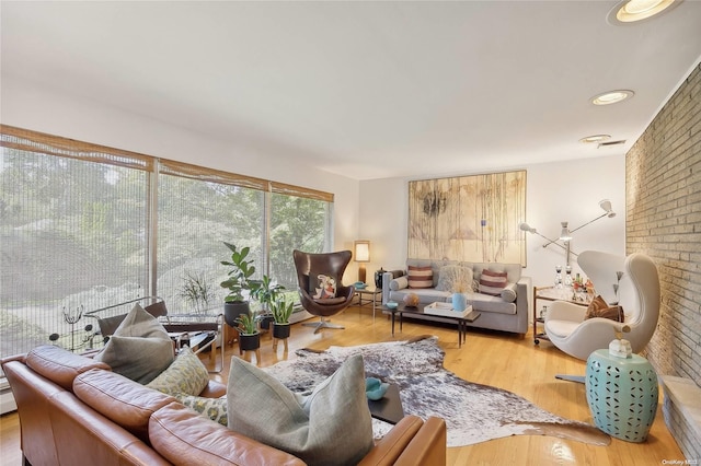 living room with wood-type flooring and brick wall