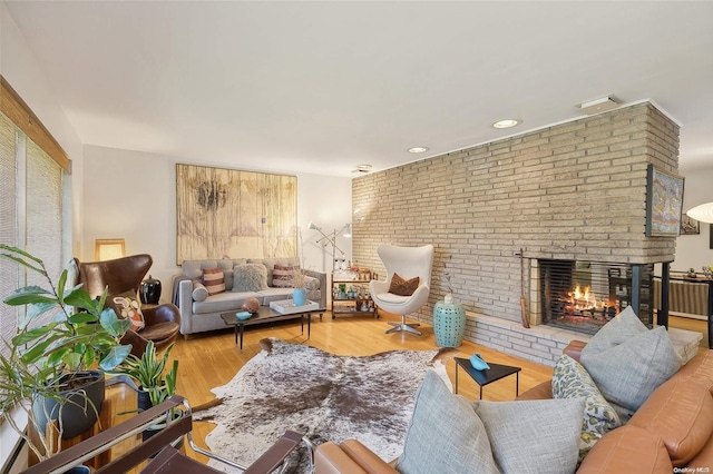 living room with wood-type flooring and a brick fireplace