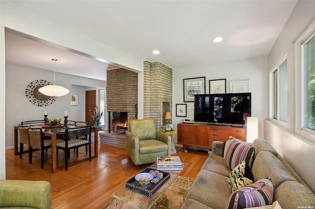 living room featuring hardwood / wood-style flooring and a brick fireplace