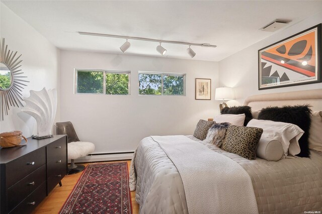 3 Pennington Dr, Huntington, NY 11743 - bedroom featuring light wood-style flooring, a baseboard heating unit, and track lighting