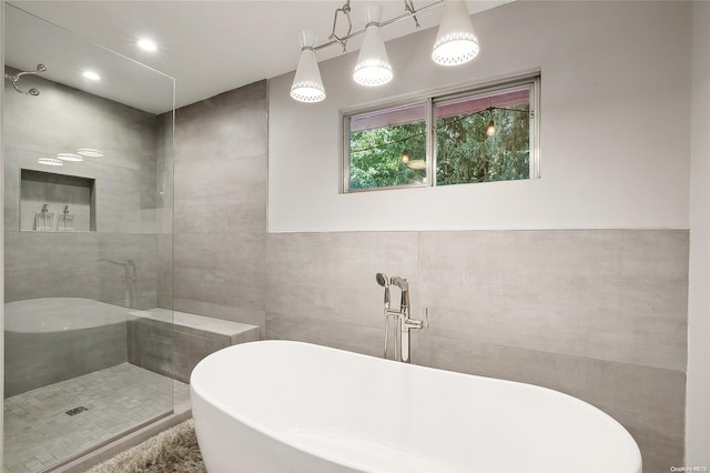 bathroom featuring a washtub and tile walls