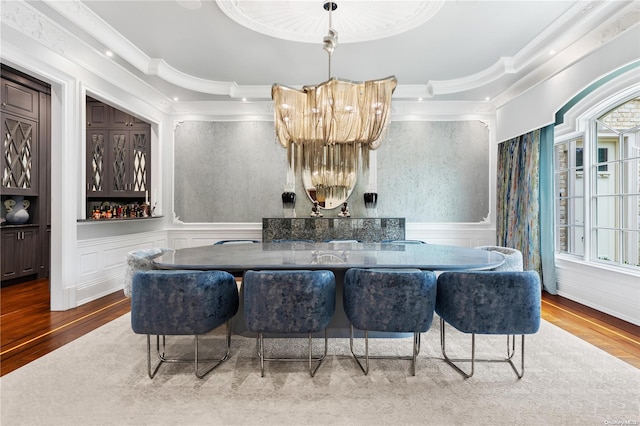 dining area with hardwood / wood-style flooring, a healthy amount of sunlight, and ornamental molding