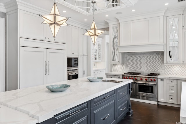 kitchen featuring built in appliances, pendant lighting, and white cabinets