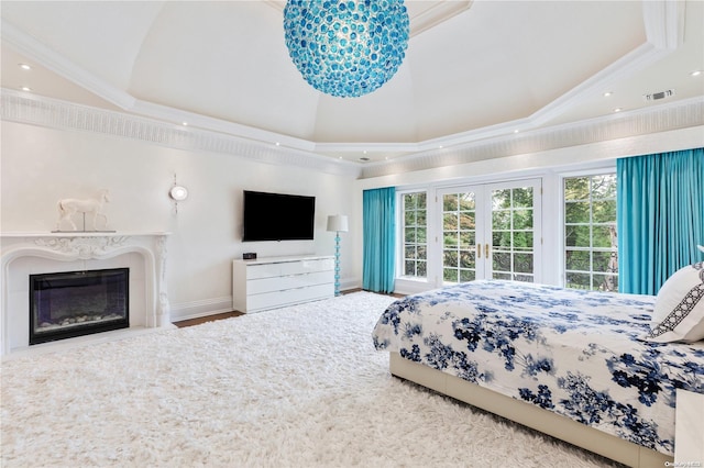 bedroom featuring french doors, a raised ceiling, crown molding, and hardwood / wood-style floors