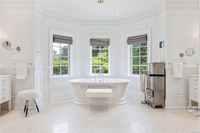 bathroom featuring vanity, a bath, and ornamental molding